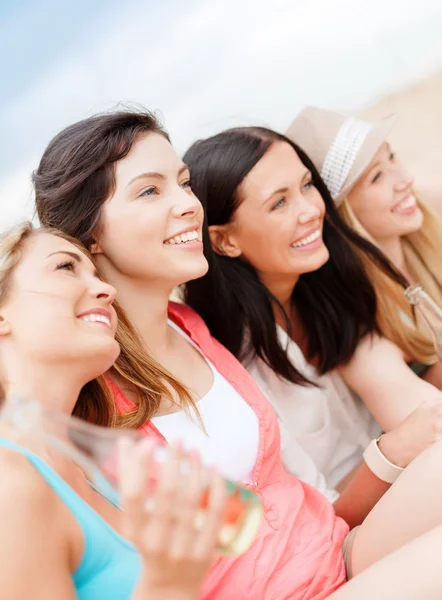 Meisjes met dranken op het strand — Stockfoto