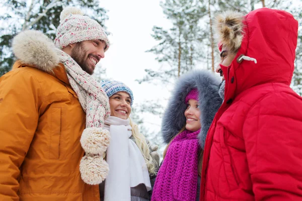 Group of smiling men and women in winter forest — Stock Photo, Image