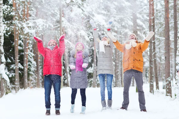 Groep gelukkige vrienden playin met sneeuw in bos — Stockfoto