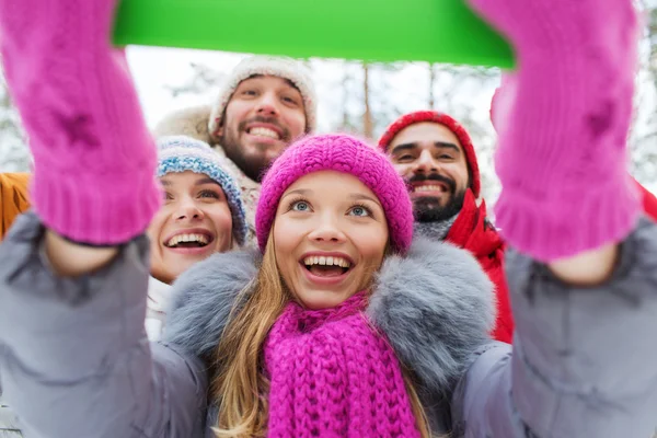 Amigos sorridentes com tablet pc na floresta de inverno — Fotografia de Stock