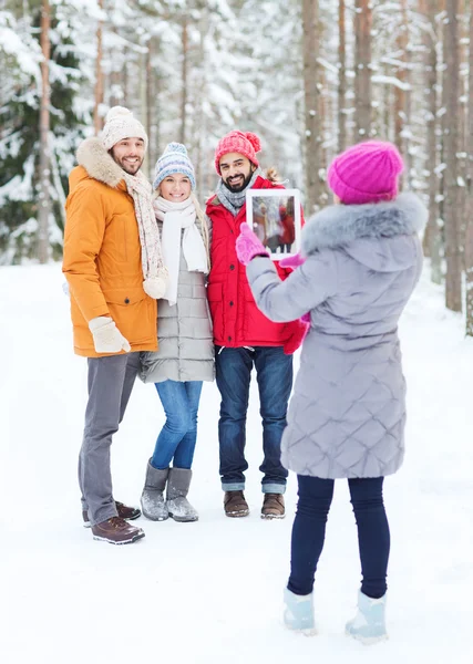 Lachende vrienden met tablet pc in winter forest — Stockfoto