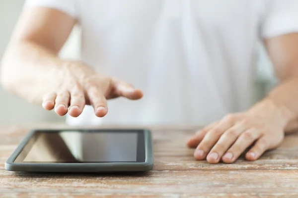 Close up of male hands with tablet pc on table — Stock Photo, Image