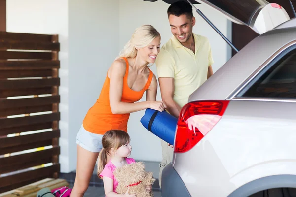 Glückliche Familie packt Dinge ins Auto — Stockfoto