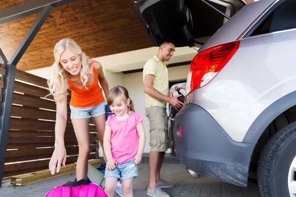 Família feliz embalando coisas para carro — Fotografia de Stock