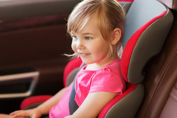 Niña feliz sentada en el asiento del coche del bebé — Foto de Stock