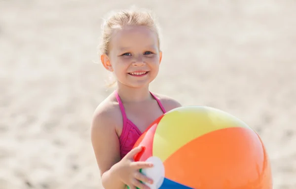 Šťastná holčička hraje nafukovací míč na pláži — Stock fotografie