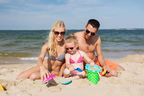 Glückliche Familie spielt mit Sandspielzeug — Stockfoto