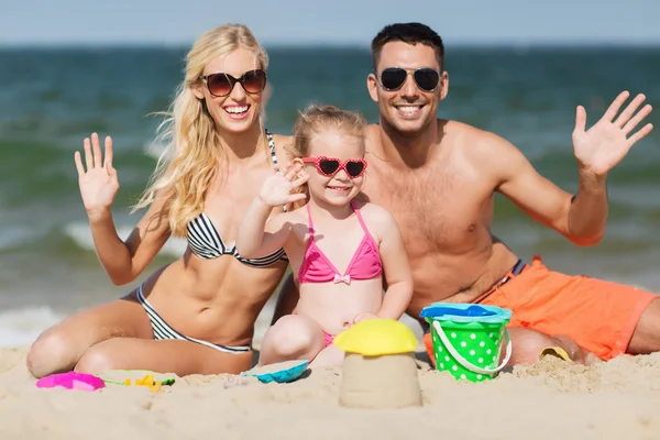 Família feliz com brinquedos de areia na praia — Fotografia de Stock