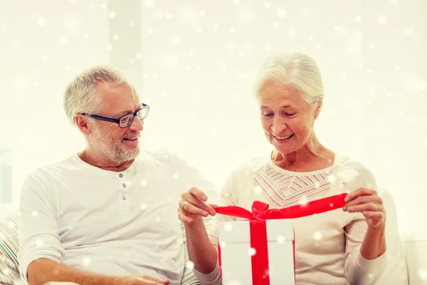 Щаслива старша пара з подарунковою коробкою вдома — стокове фото