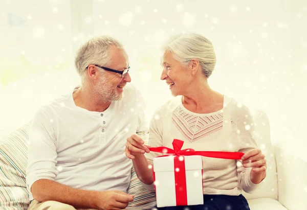 Щаслива старша пара з подарунковою коробкою вдома — стокове фото
