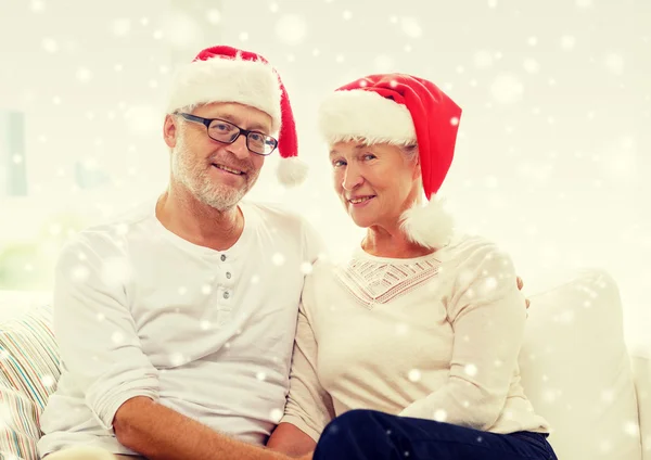 Pasangan senior bahagia dengan topi pembantu Santa di rumah. — Stok Foto