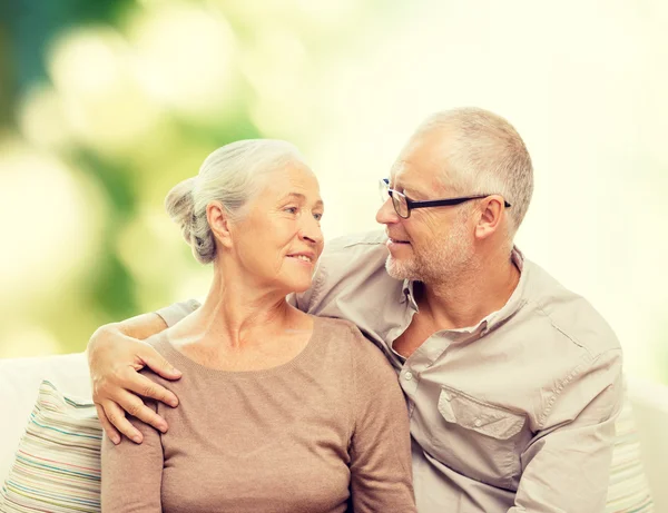 Feliz pareja de ancianos abrazándose en el sofá en casa —  Fotos de Stock