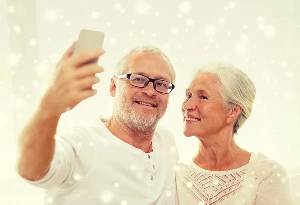 Glad äldre par med smartphone hemma — Stockfoto