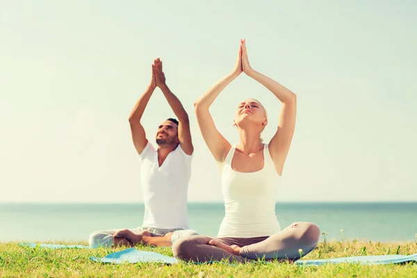 Paar maken yoga oefeningen buiten — Stockfoto