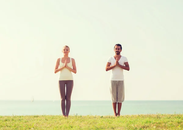 Paar maken yoga oefeningen buiten — Stockfoto