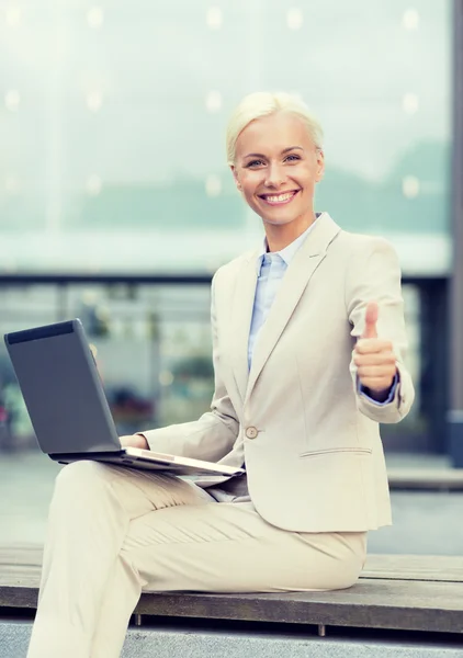 Sonriente mujer de negocios trabajando con el ordenador portátil al aire libre —  Fotos de Stock