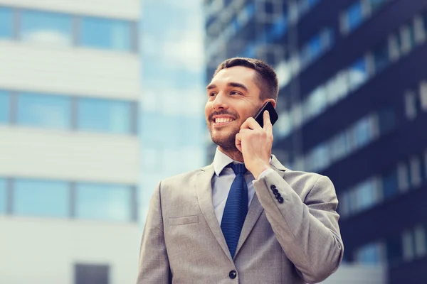 Hombre de negocios sonriente con teléfono inteligente al aire libre —  Fotos de Stock