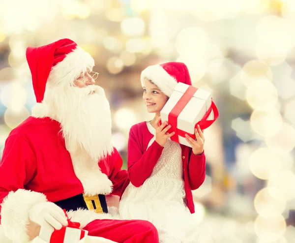 Petite fille souriante avec santa claus et cadeaux — Photo