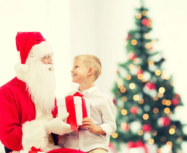 Uśmiechnięty chłopczyk z santa claus i prezenty — Zdjęcie stockowe
