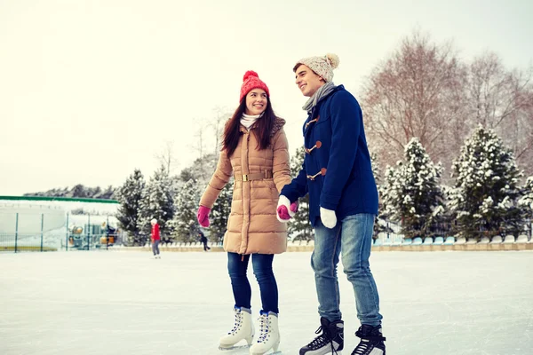 Feliz pareja patinaje sobre hielo en pista al aire libre —  Fotos de Stock