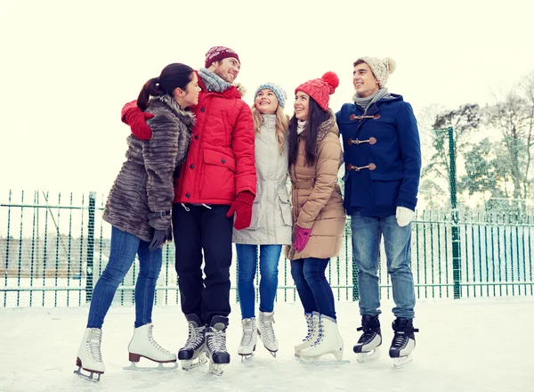 Happy přátelé bruslení na kluzišti venku — Stock fotografie