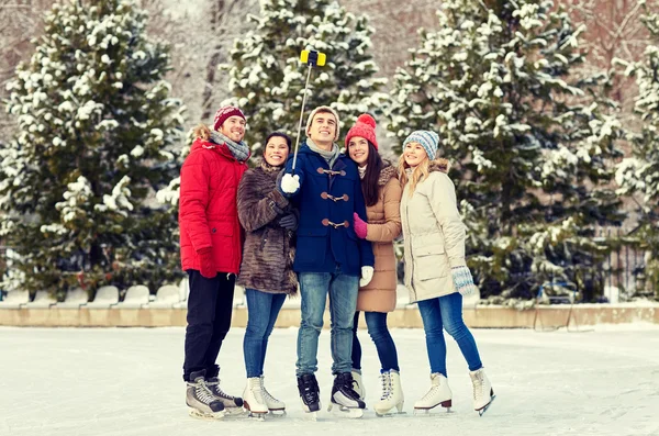 Mutlu arkadaş grubu buz buz pateni pisti smartphone — Stok fotoğraf