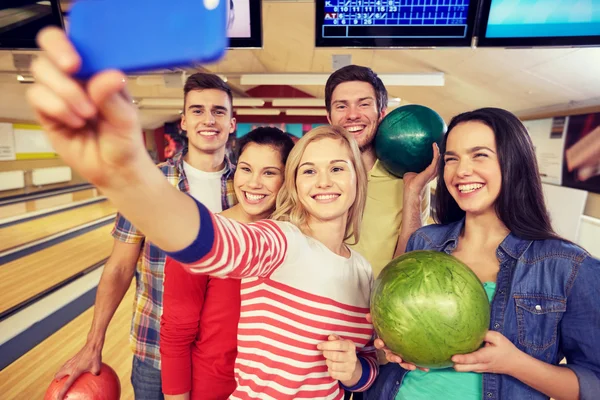 Glückliche Freunde mit Smartphone im Kegelclub — Stockfoto