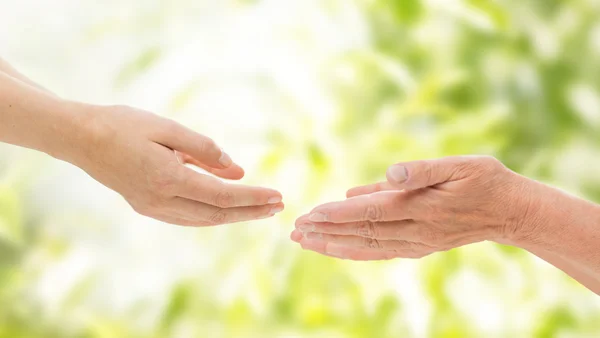 Närbild på senior och ung kvinna händer — Stockfoto