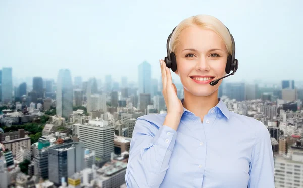 Operador de línea de ayuda en auriculares sobre el fondo de la ciudad — Foto de Stock