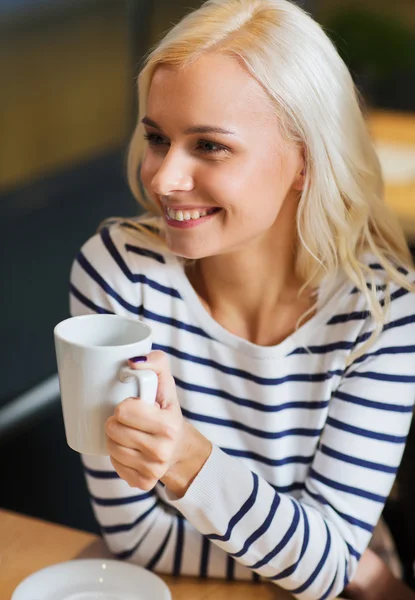 Gelukkig jonge vrouw drinken thee of koffie — Stockfoto