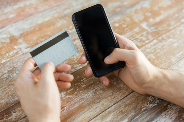 Perto de mãos com telefone inteligente e cartão de crédito — Fotografia de Stock