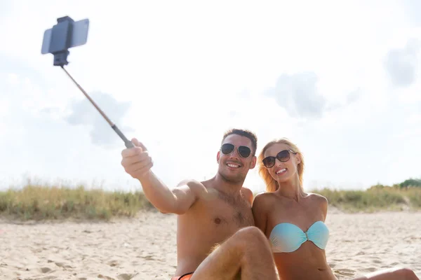 Gelukkige paar in badmode zittend op zomer strand — Stockfoto