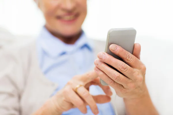 close up of senior woman with smartphone texting