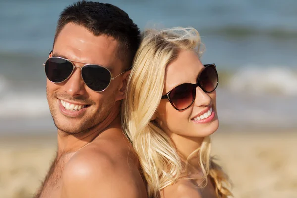 Gelukkige paar in badmode zittend op zomer strand — Stockfoto