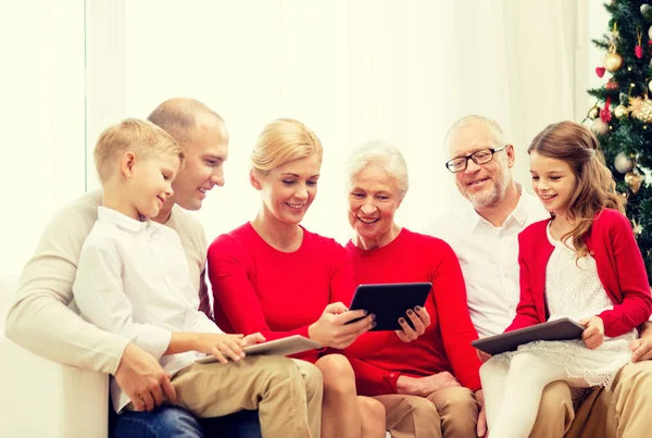 Família sorrindo com computadores tablet pc em casa Fotografias De Stock Royalty-Free