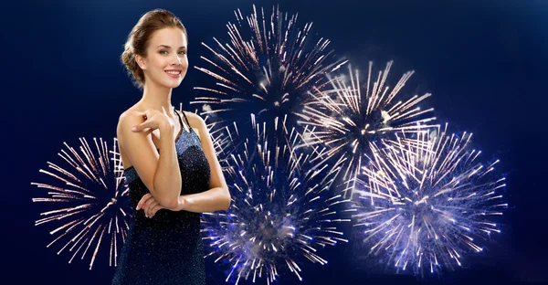 Schöne Frau im Abendkleid über Feuerwerk — Stockfoto