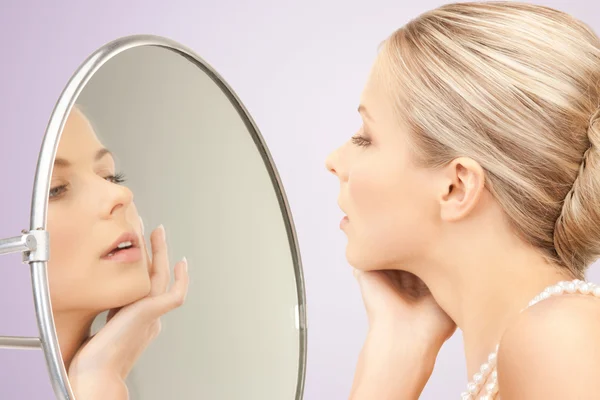 Vacker kvinna med pärlhalsband och spegel — Stockfoto