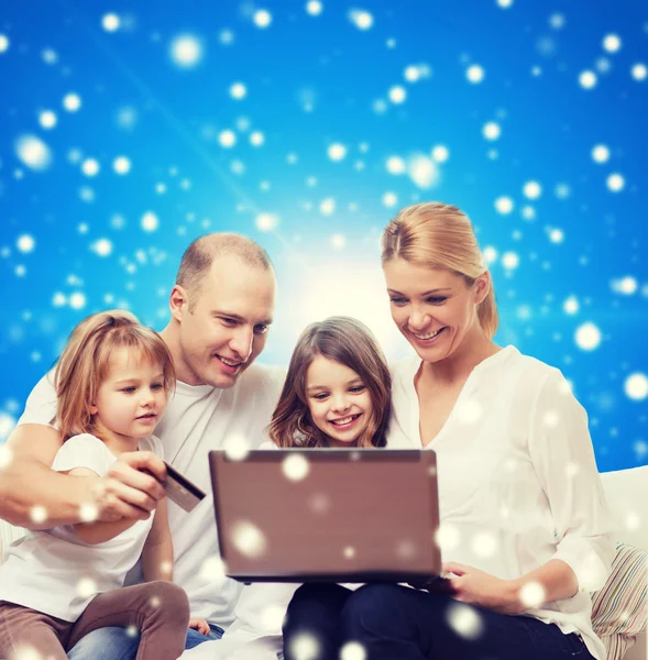 Familia feliz con ordenador portátil y tarjeta de crédito —  Fotos de Stock