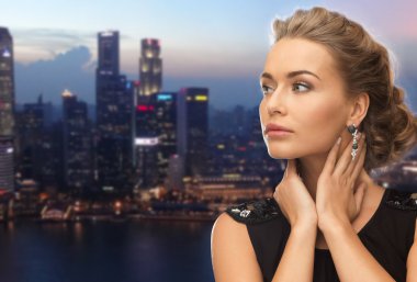 beautiful woman wearing earrings over evening city clipart