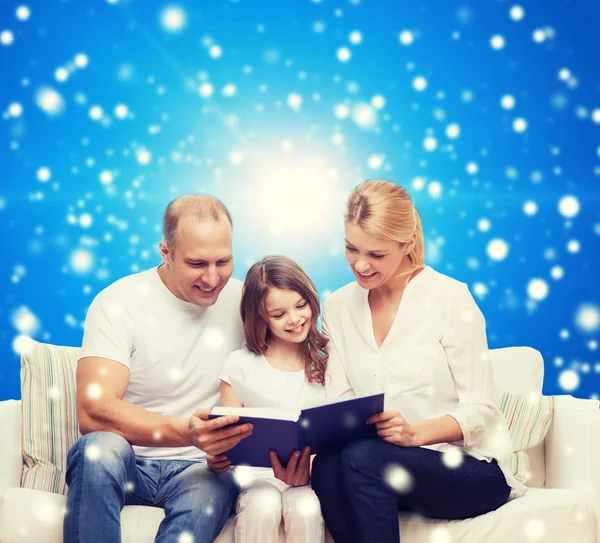 Família feliz com livro em casa — Fotografia de Stock