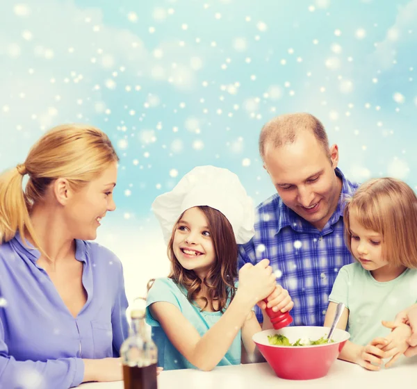 Glückliche Familie mit zwei Kindern, die zu Hause Salat zubereiten — Stockfoto