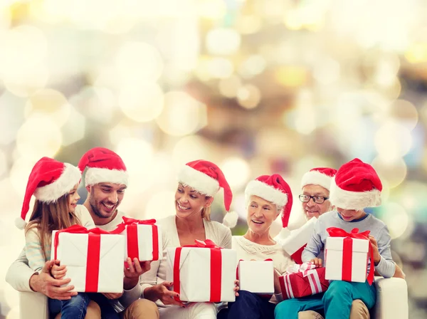 Família feliz em santa helper chapéus com caixas de presente — Fotografia de Stock