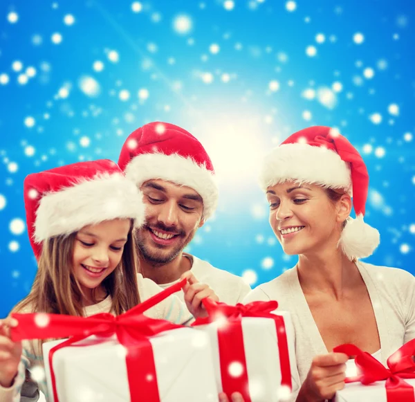 Familia feliz en sombreros de santa helper con cajas de regalo —  Fotos de Stock