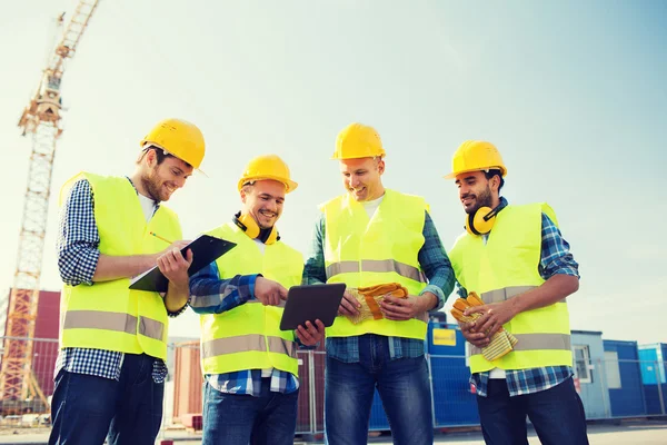 Gruppo di costruttori sorridenti con tablet pc all'aperto — Foto Stock