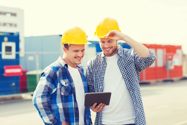 Constructores sonrientes en sombreros con tablet pc —  Fotos de Stock