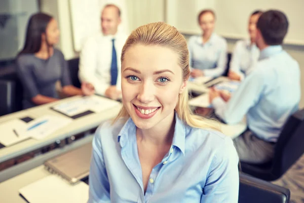 Grupo de empresarios sonrientes reunidos en el cargo — Foto de Stock