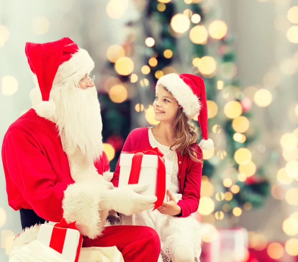 Lachende meisje met santa claus en giften — Stockfoto