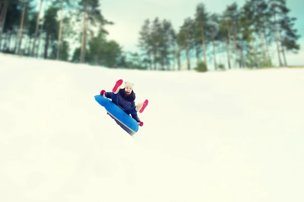 Feliz adolescente deslizándose hacia abajo en el tubo de nieve — Foto de Stock