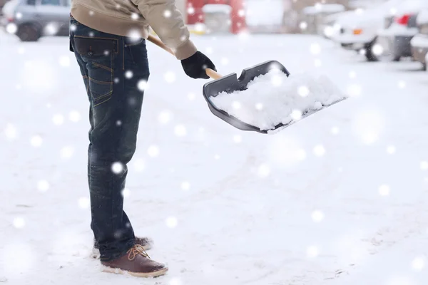 Zbliżenie człowieka kopanie śniegu łopatą w pobliżu samochodu — Zdjęcie stockowe