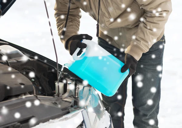 Großaufnahme eines Mannes, der Frostschutzmittel ins Auto schüttet — Stockfoto